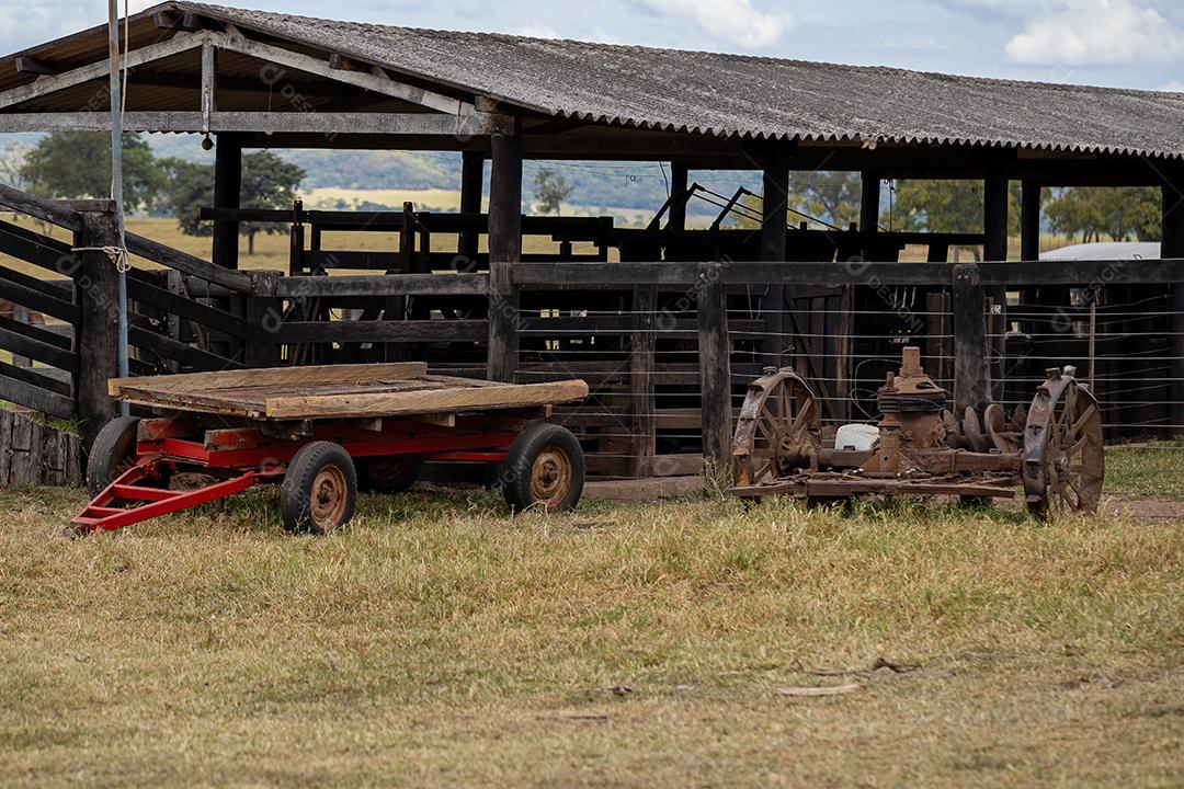 Curral de madeira para manuseio de gado na fazenda com equipamento de trator estacionado
