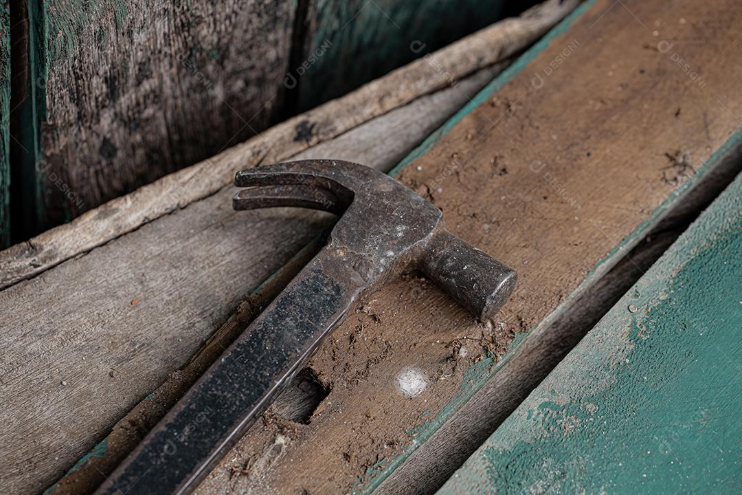 Martelo de metal sob superfície de madeira suja em um edifício rural