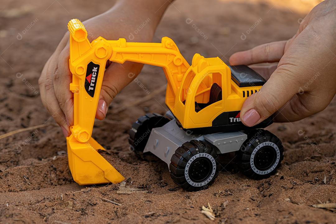 Miniatura de escavadeira de brinquedo de cor amarela e preta no chão