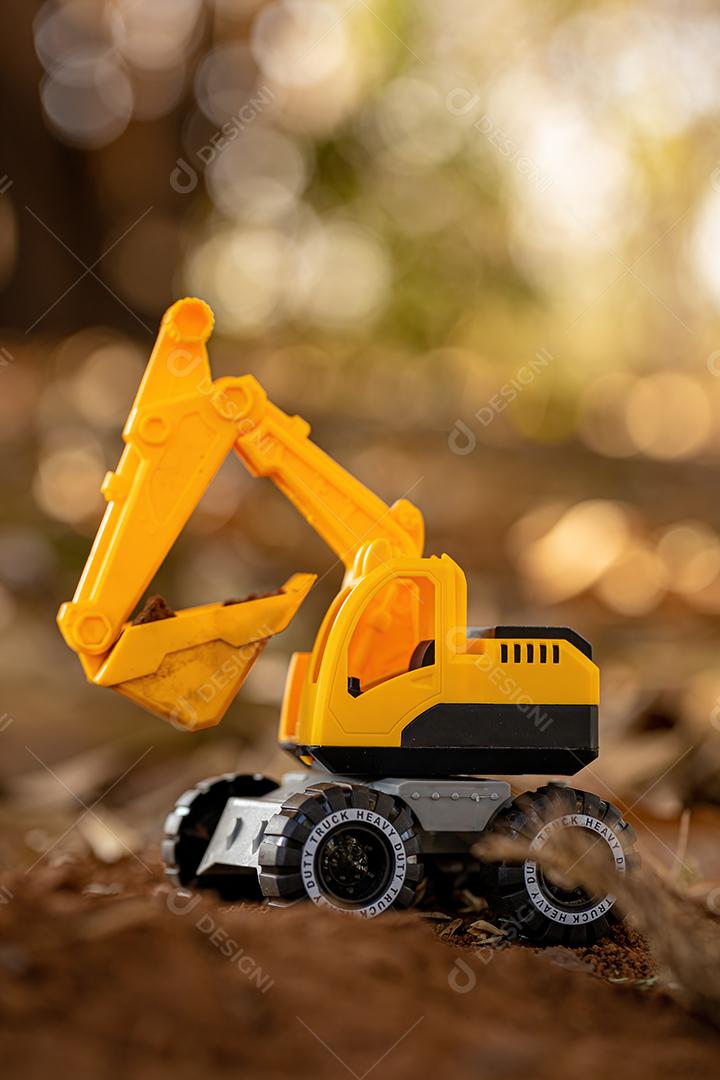 Miniatura de escavadeira de brinquedo de cor amarela e preta no chão