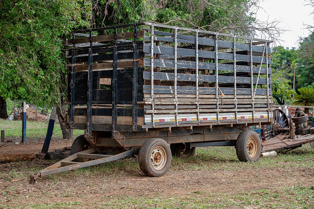 Pequeno reboque com grade para transporte de gado para anexar ao trator