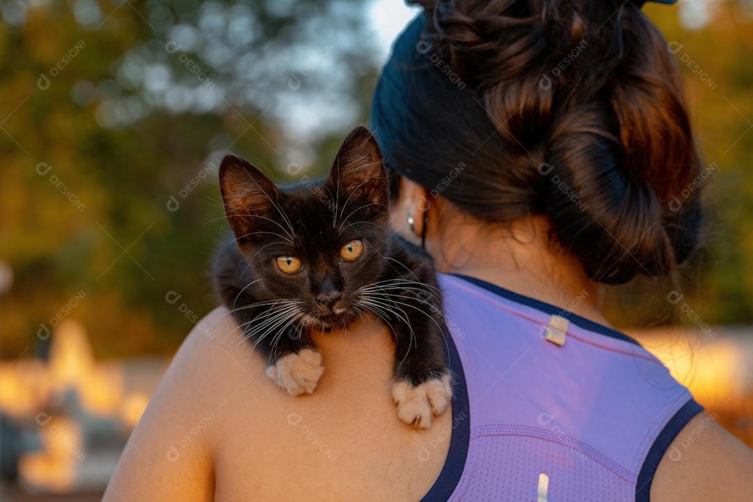 Gatinho Preto Encostado no Ombro de uma Garota Imagem JPG
