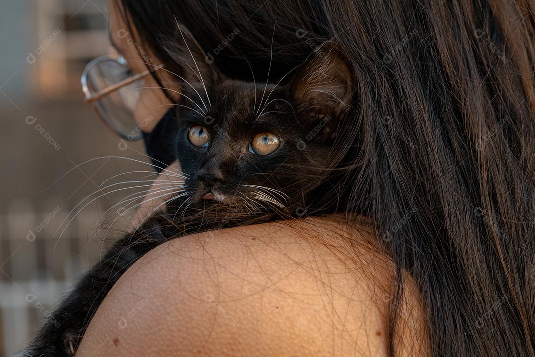 Gatinho Preto Encostado no Ombro de uma Garota Imagem JPG