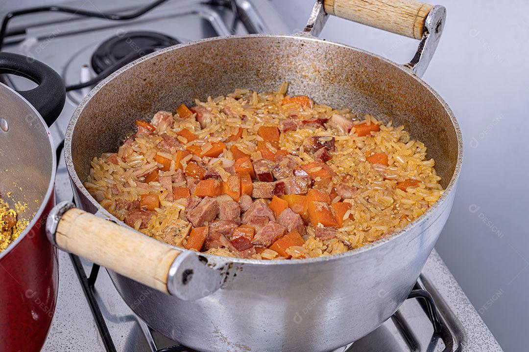 Arroz integral com Pedaços de Cenoura e Linguiça Calabresa Cozinhando Imagem JPG