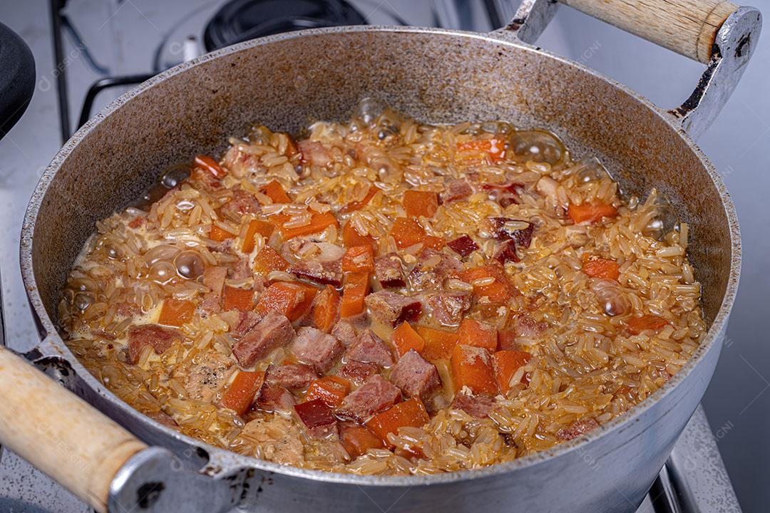 Arroz integral com Pedaços de Cenoura e Linguiça Calabresa Cozinhando Imagem JPG