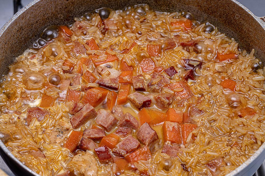 Arroz integral com Pedaços de Cenoura e Linguiça Calabresa Cozinhando Imagem JPG
