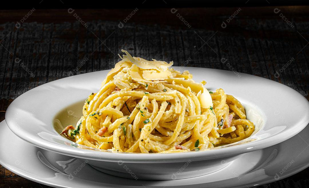 Foto Espaguete Com Ovo Bacon e Salsa Derretido Dentro de Um Queijo Grana Padano