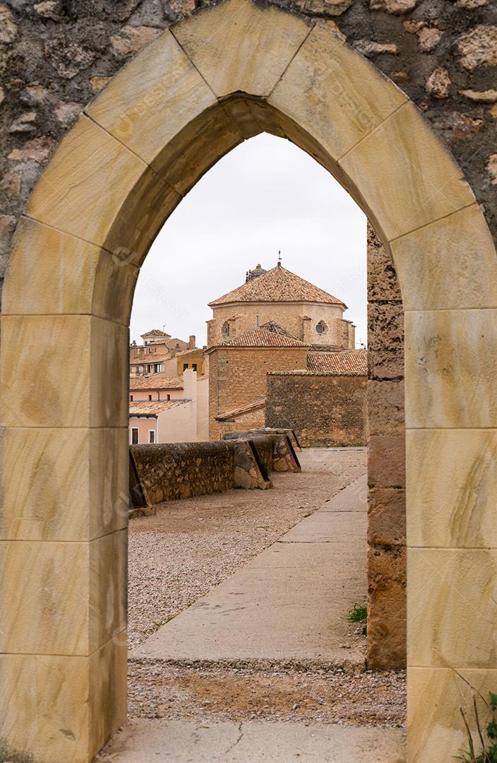 vista da igreja através de uma porta gótica na parede de Cuenca em Casti