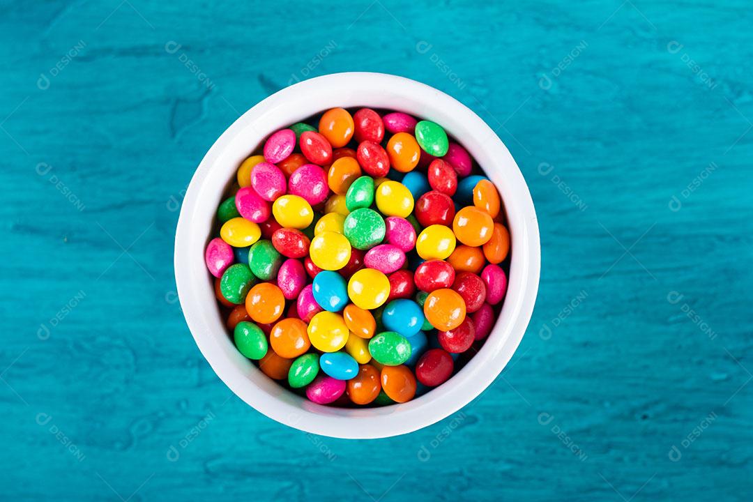 Doces de Confetes Coloridos Em Tigela Com Fundo Azul Imagem JPG