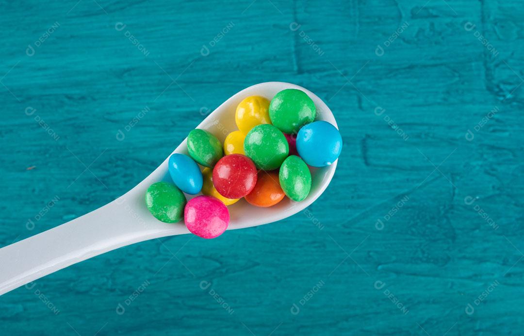 Doces de Confetes Coloridos Em Tigela Com Fundo Azul Imagem JPG