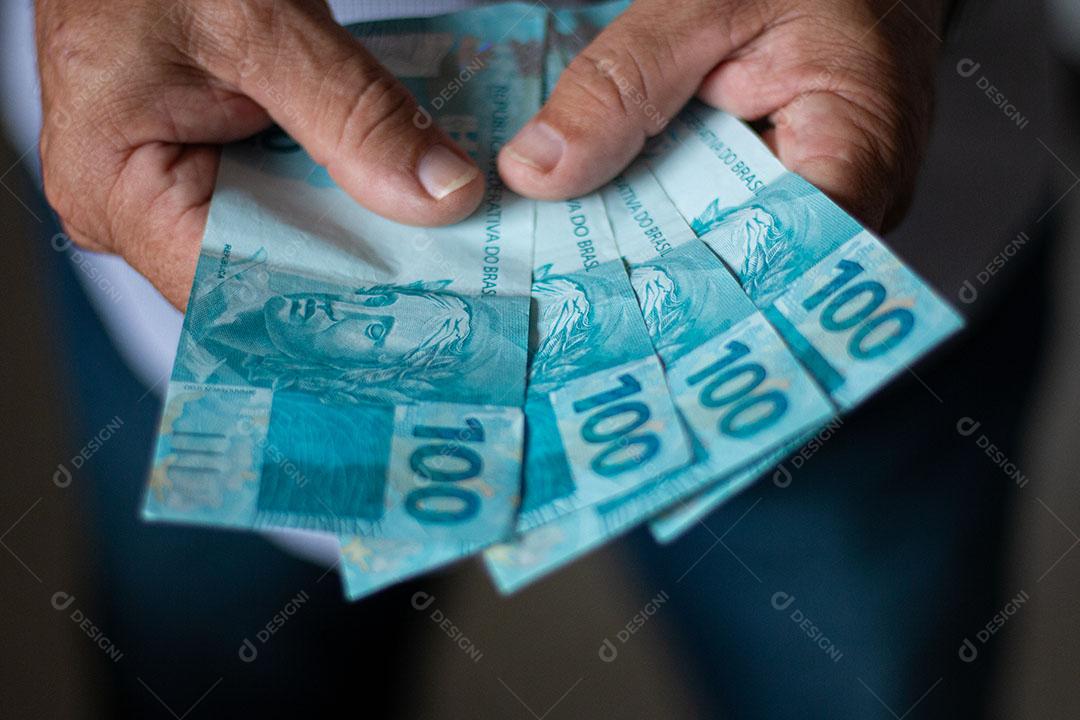 Homem Segurando Notas de Dinheiro Brasileiro Com a Mão Imagem JPG