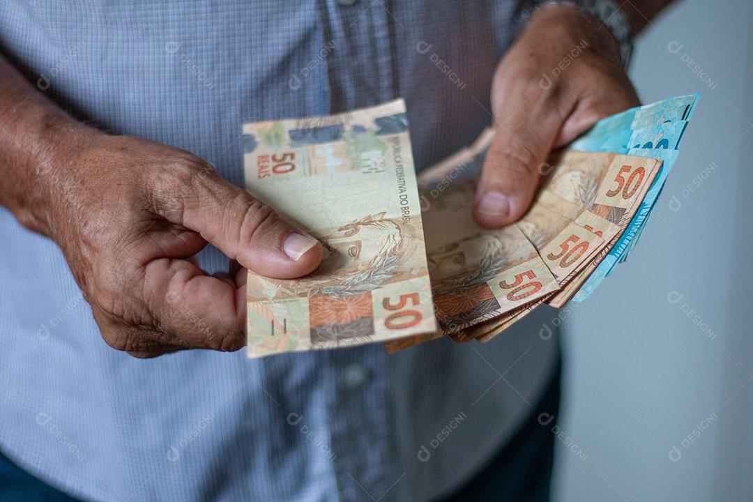 Homem Segurando Notas de Dinheiro Brasileiro Com a Mão Imagem JPG