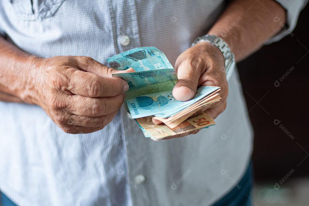 Homem Segurando Notas de Dinheiro Brasileiro Com a Mão Imagem JPG