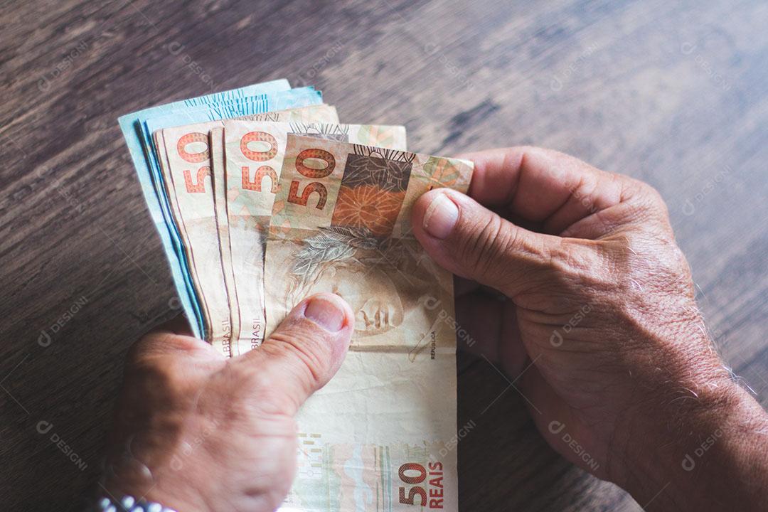 Homem Segurando Notas de Dinheiro Brasileiro Com a Mão Imagem JPG