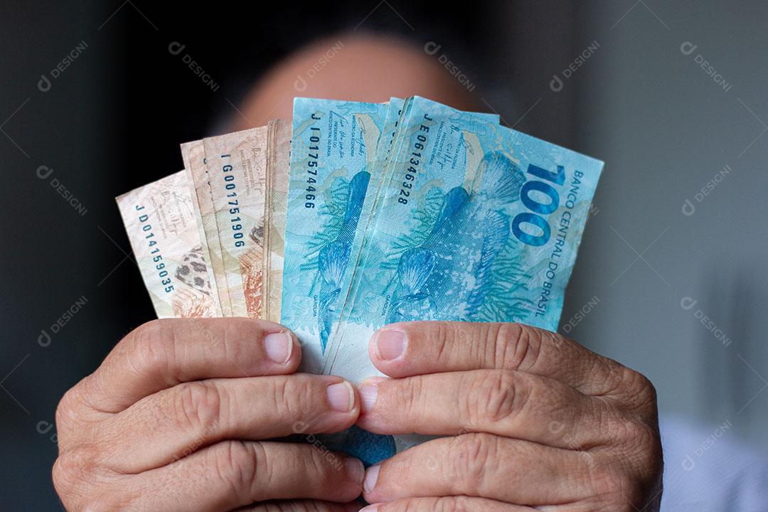 Homem Segurando Notas de Dinheiro Brasileiro Com a Mão Imagem JPG