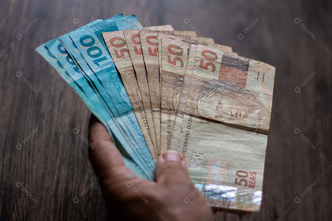 Homem Segurando Notas de Dinheiro Brasileiro Com a Mão Imagem JPG