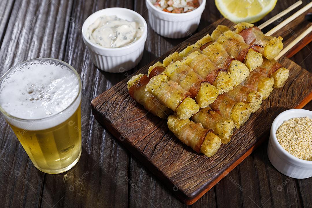 Espetinhos de mandioca enrolados no bacon medalhão de mandioca Imagem JPG