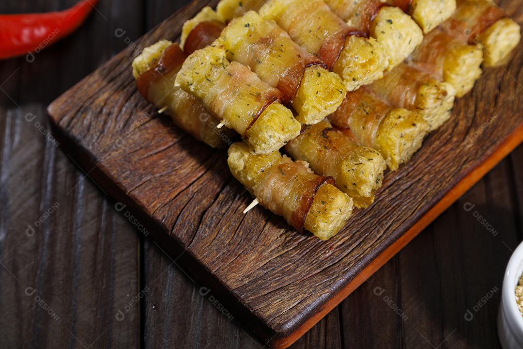 Espetinhos de mandioca enrolados no bacon medalhão de mandioca Imagem JPG