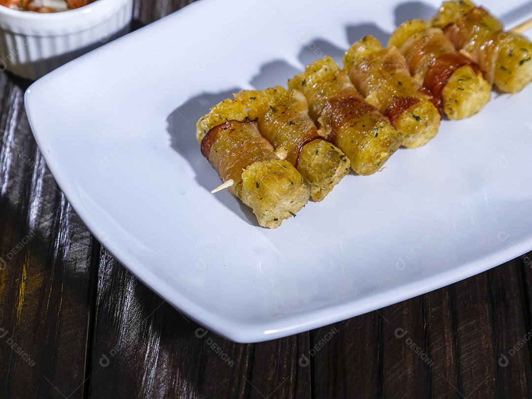 Espetinhos de mandioca enrolados no bacon medalhão de mandioca Imagem JPG