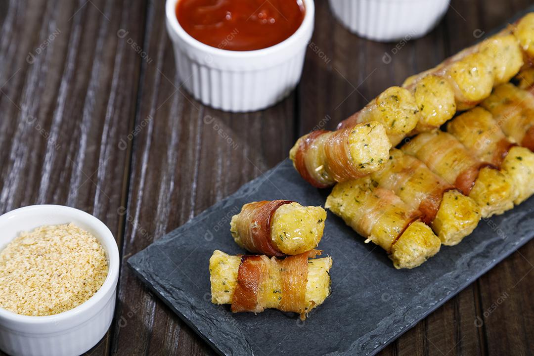 Espetinhos de mandioca enrolados no bacon medalhão de mandioca Imagem JPG