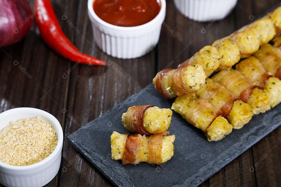 Espetinhos de mandioca enrolados no bacon medalhão de mandioca Imagem JPG