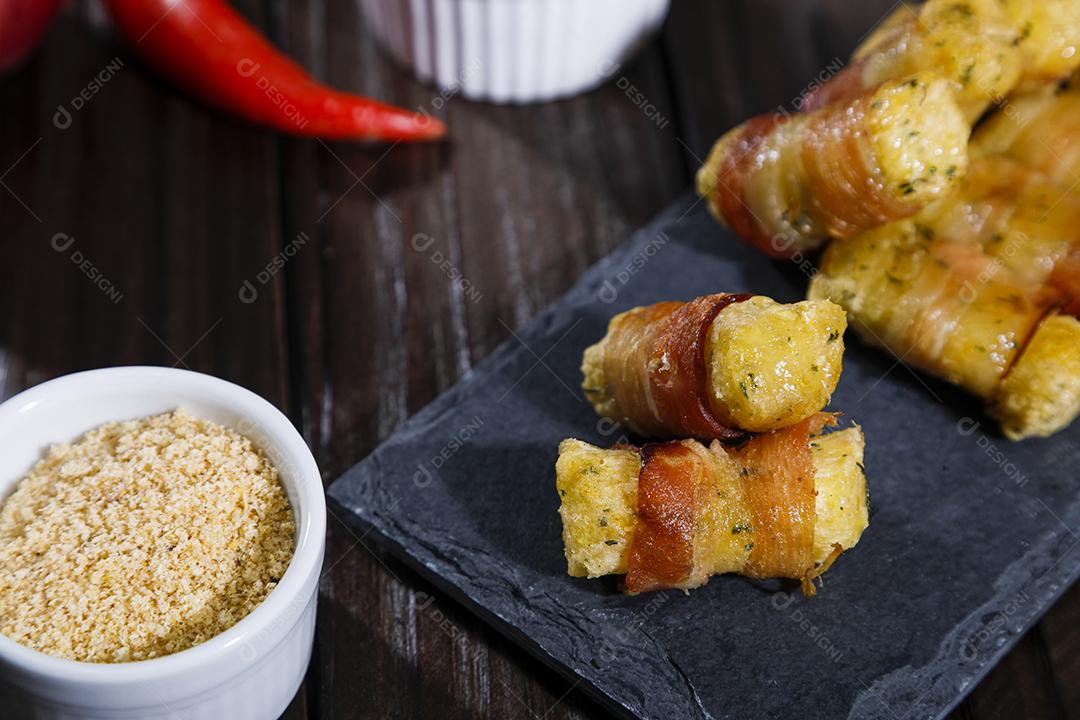 Espetinhos de mandioca enrolados no bacon medalhão de mandioca Imagem JPG