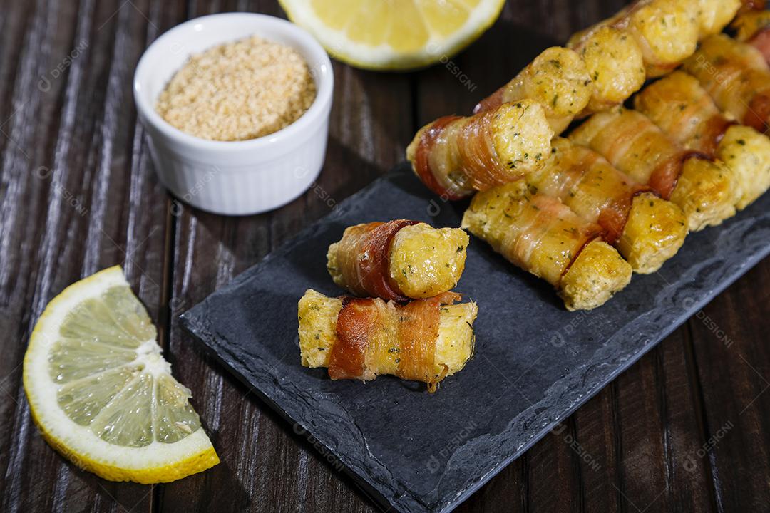 Espetinhos de mandioca enrolados no bacon medalhão de mandioca Imagem JPG