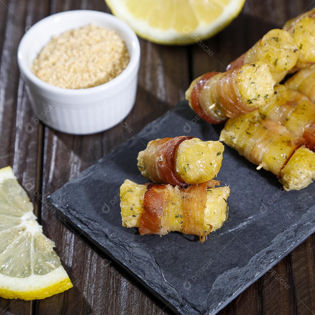 Espetinhos de mandioca enrolados no bacon medalhão de mandioca Imagem JPG