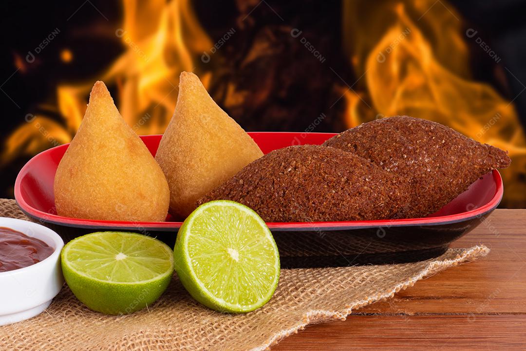 Foto Coxinha e Kibe Comida Brasileira Frita Tradicional Fundo Com Fogo Desfocado