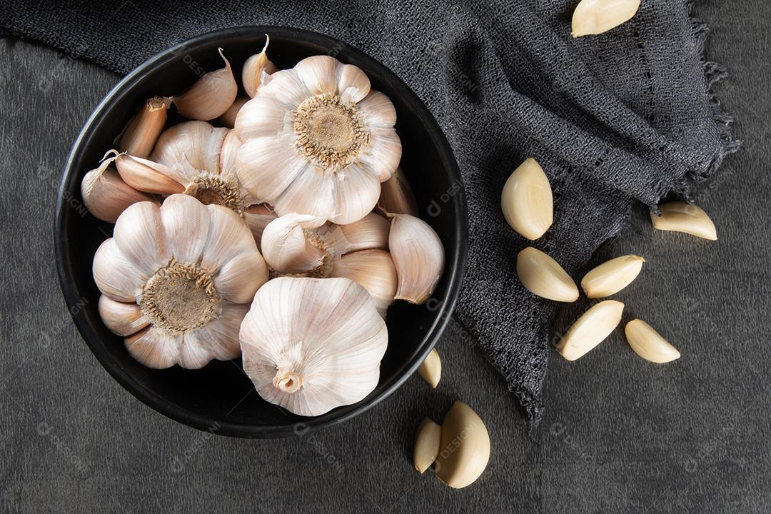 Dentes de Alho e Bulbo Em Tigela Preta Em Tecido e Fundo Escuro Imagem JPG
