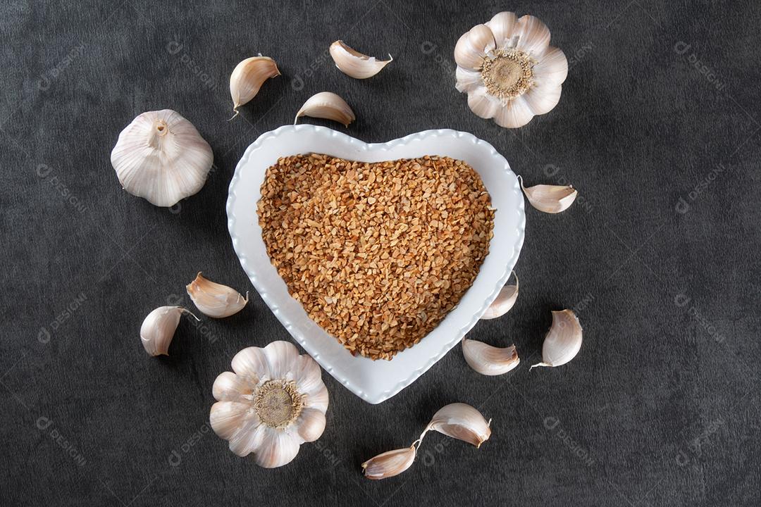 Dentes de Alho e Bulbo na Tigela de Coração Com Fundo Escuro Imagem JPG
