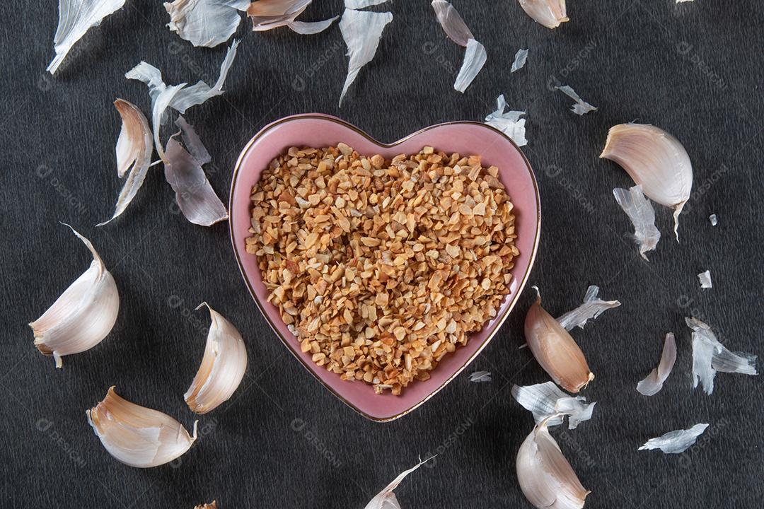 Dentes de Alho e Bulbo na Tigela de Coração Com Fundo Escuro Imagem JPG