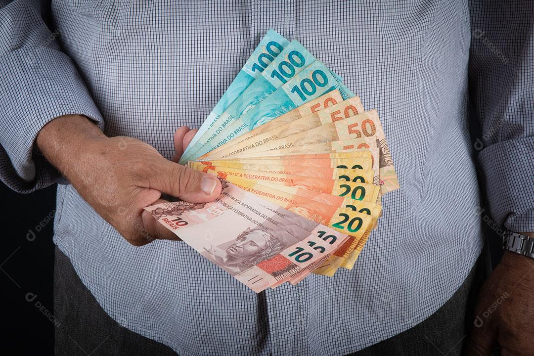 Homem Segurando o Conceito de Finanças de Notas de Dinheiro Brasileiro Imagem JPG