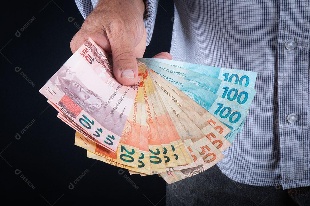 Homem Segurando o Conceito de Finanças de Notas de Dinheiro Brasileiro Imagem JPG