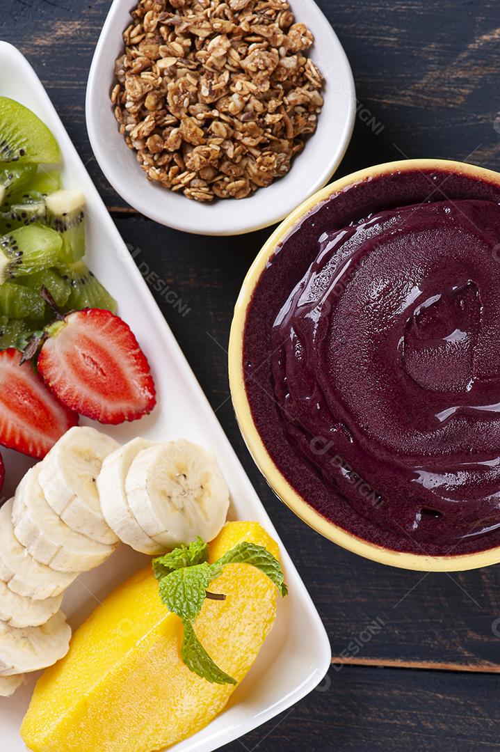 Açaí brasileiro em uma tigela acompanhada de frutas tropicais JPG