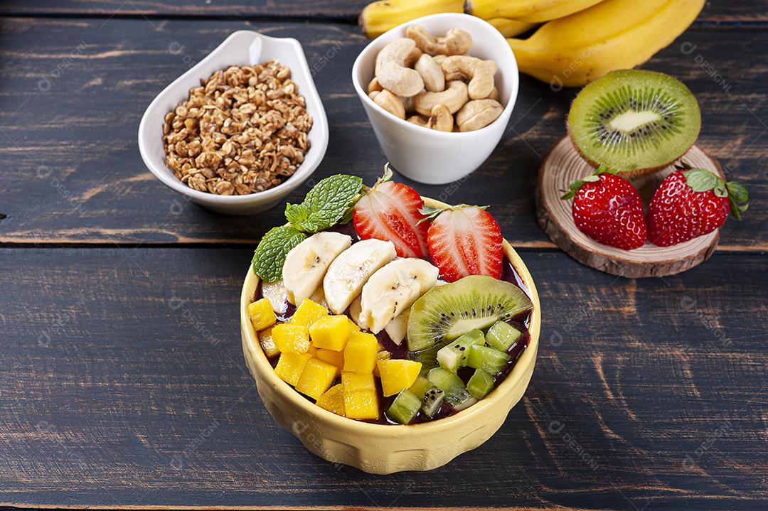 Açaí brasileiro em uma tigela acompanhada de frutas tropicais JPG