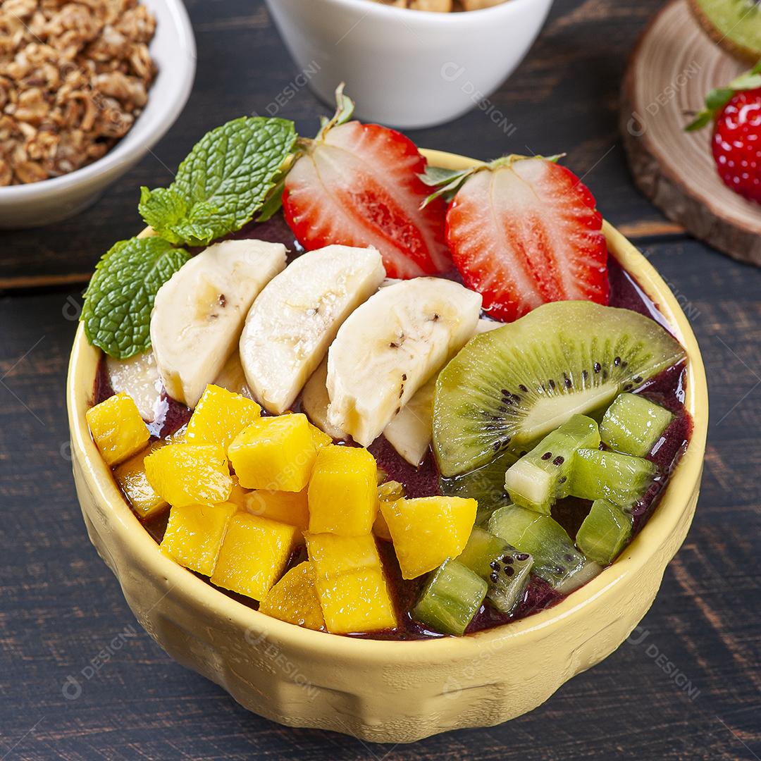 Açaí brasileiro em uma tigela acompanhada de frutas tropicais JPG