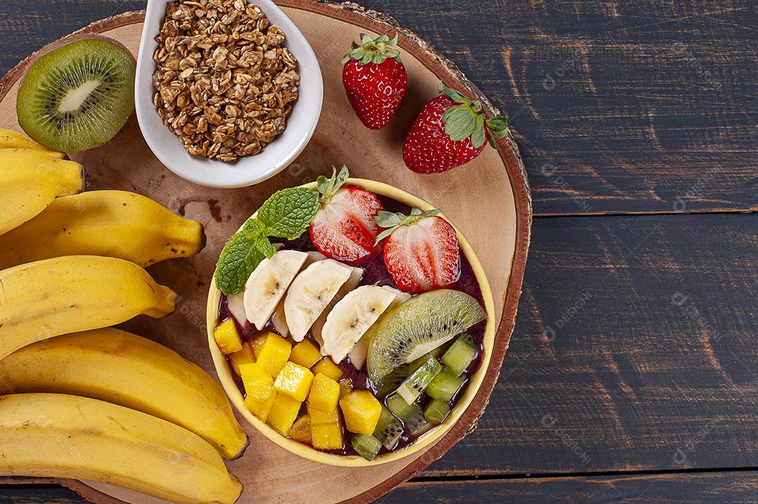 Açaí brasileiro em uma tigela acompanhada de frutas tropicais JPG