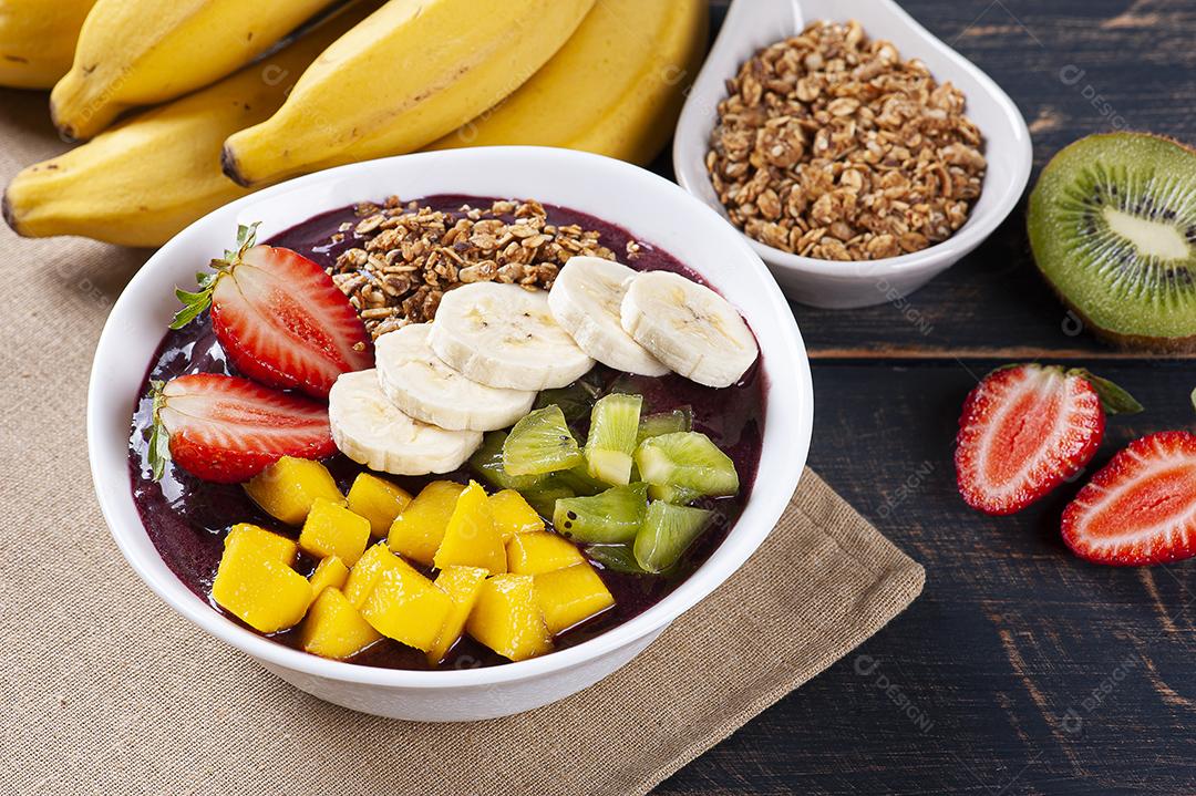Açaí brasileiro em uma tigela acompanhada de frutas tropicais JPG
