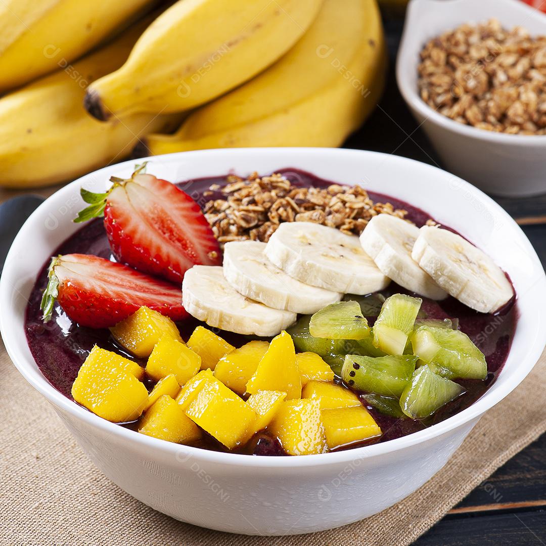 Açaí brasileiro em uma tigela acompanhada de frutas tropicais JPG