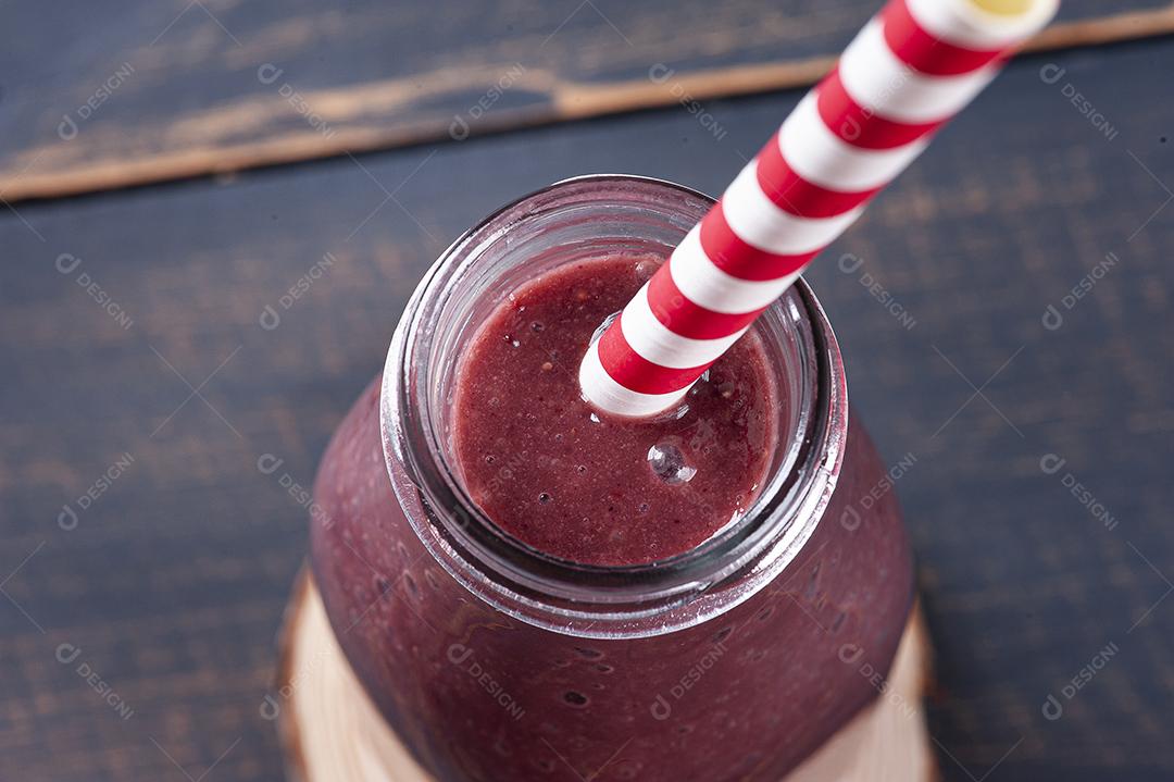 Delicioso smoothie de açaí em uma garrafa com frutas tropicais JPG