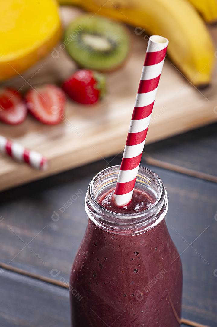 Delicioso smoothie de açaí em uma garrafa com frutas tropicais JPG