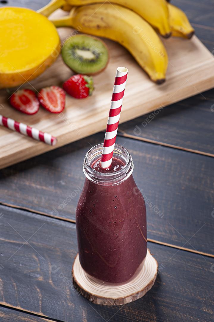 Delicioso smoothie de açaí em uma garrafa com frutas tropicais JPG