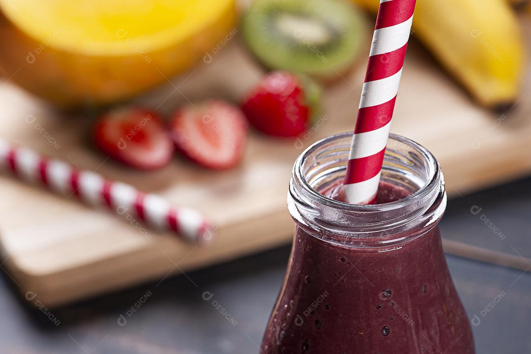 Delicioso smoothie de açaí em uma garrafa com frutas tropicais JPG