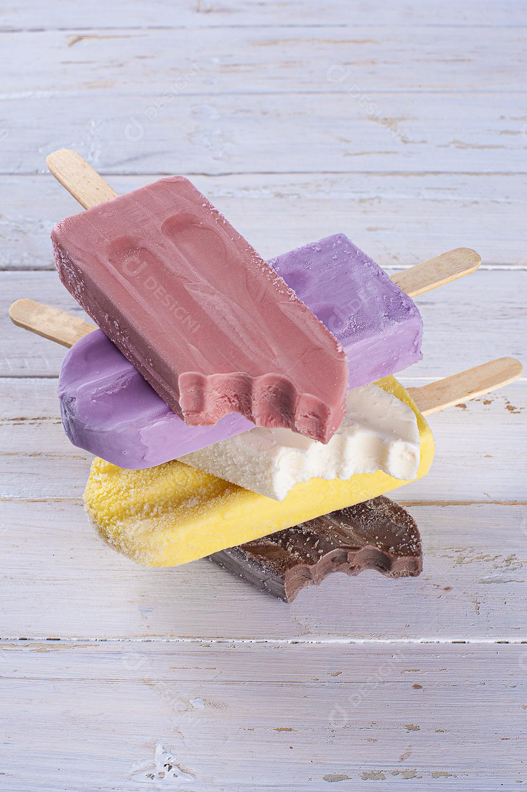 Picolé de uva destacado com vários picolés de sabores variados juntos Imagem JPG