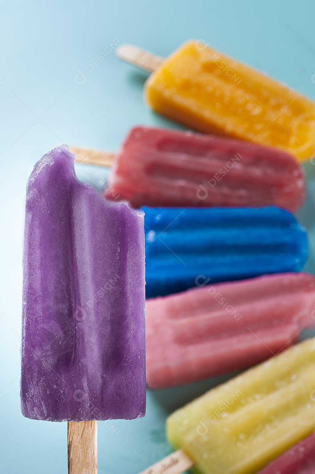 Picolé de uva destacado com vários picolés de sabores variados juntos Imagem JPG