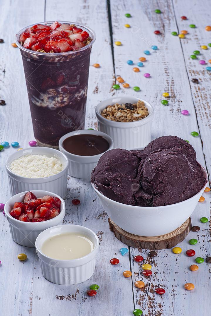 Açaí congelado em copo plástico e tigela branca com frutas JPG