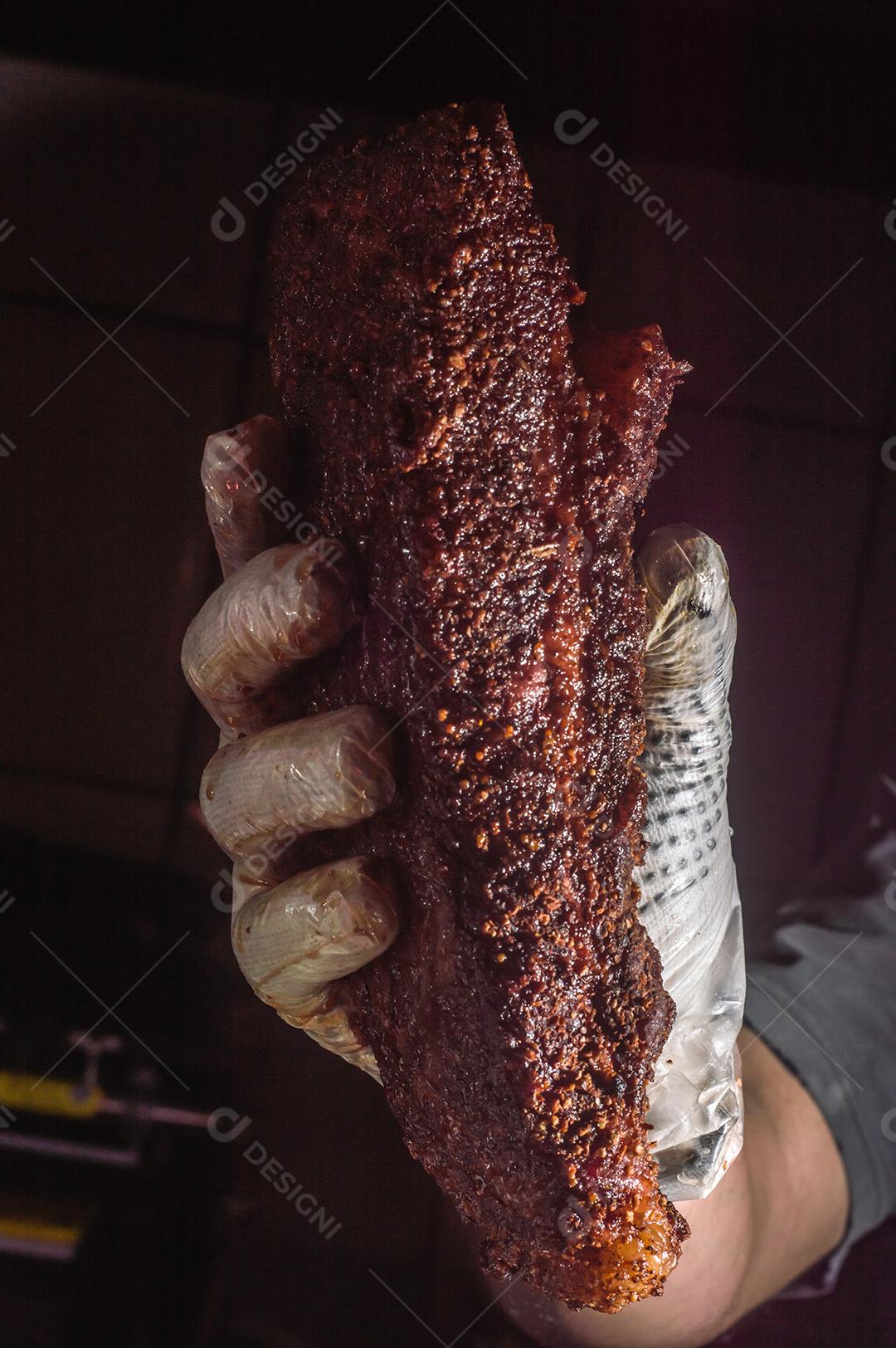 Mão Com Luva Segurando Um Pedaço de Brisket, Fundo Escuro Imagens jpg