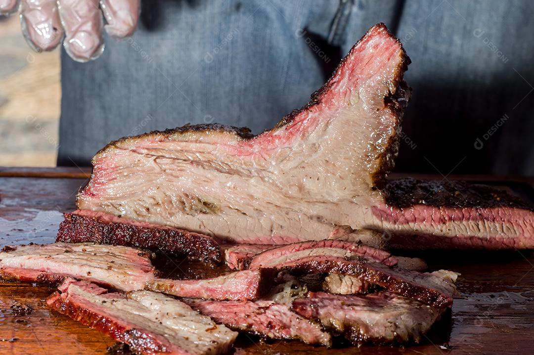 Fotos Homem cortando e manipulando um pedaço de peito defumado, com luz natural