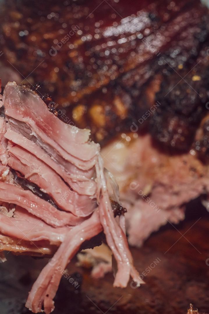 Joelho de porco fatiado em uma placa de madeira e faca de mão Imagem JPG